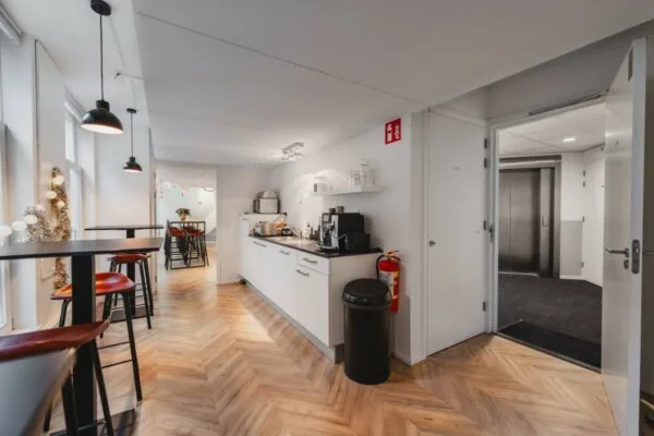 Moderne gedeelde pantry en zithoek in een kantoorruimte aan de Korte Reguliersdwarsstraat.